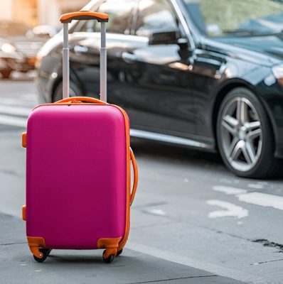 Full size bottom view young traveler businessman young man in black dinner suit going walk outside at international airport terminal with suitcase to car booking taxi Air flight business trip concept.